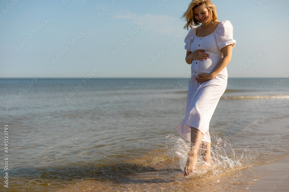 怀孕的美女赤脚走在海边