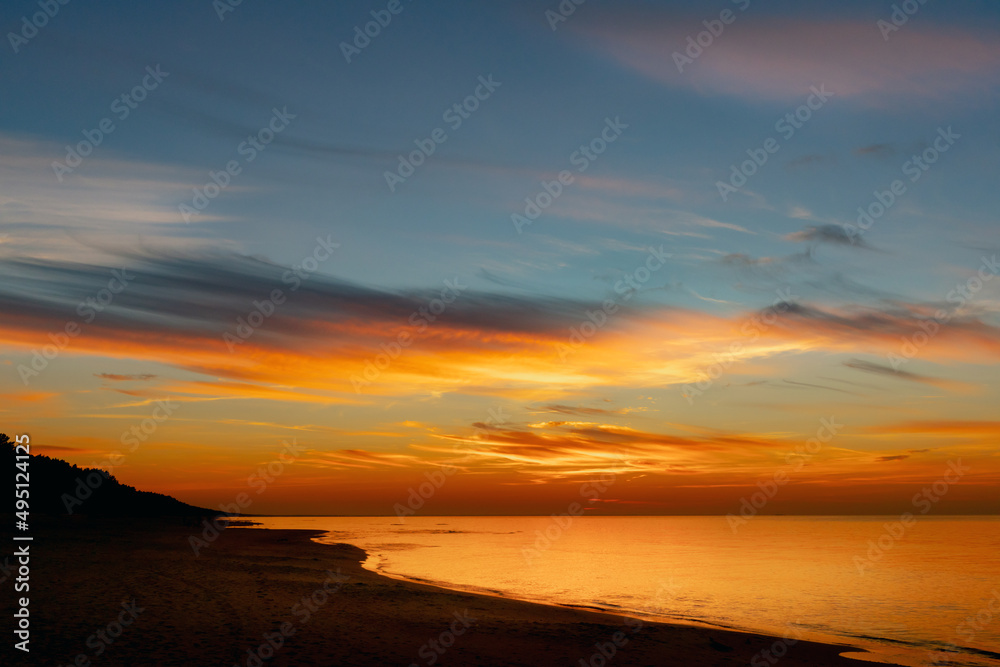 Stunning colorful sunset on the seashore with sandy beach