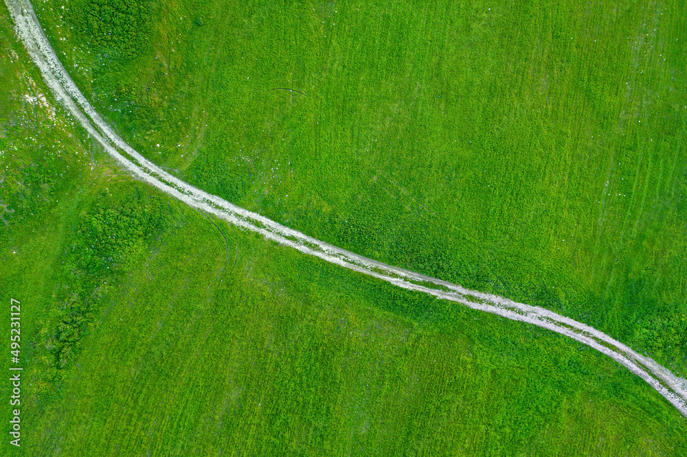 穿过绿草地的乡村道路，正上方鸟瞰图