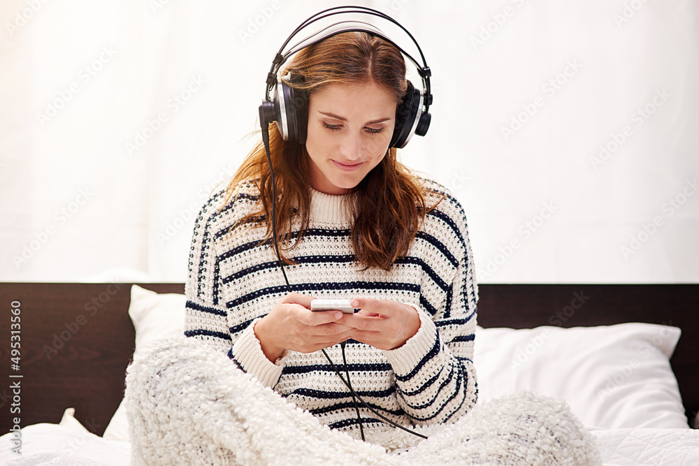 Selecting her favourite songs. Cropped shot of a beautiful young woman listening to music at home.