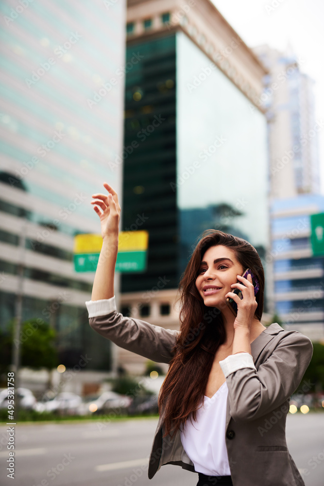 Hold on, Im just calling a cab. Cropped shot of an attractive young businesswoman hailing for a taxi