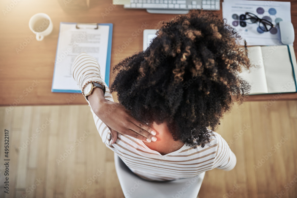 Shes starting to feel it in her neck. Rearview shot of a young woman experiencing neck pain while wo