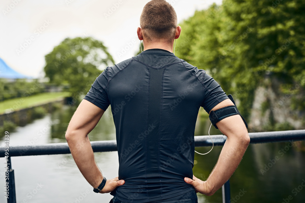 Look towards a better you. Rearview shot of a sporty young man taking a break while exercising outdo