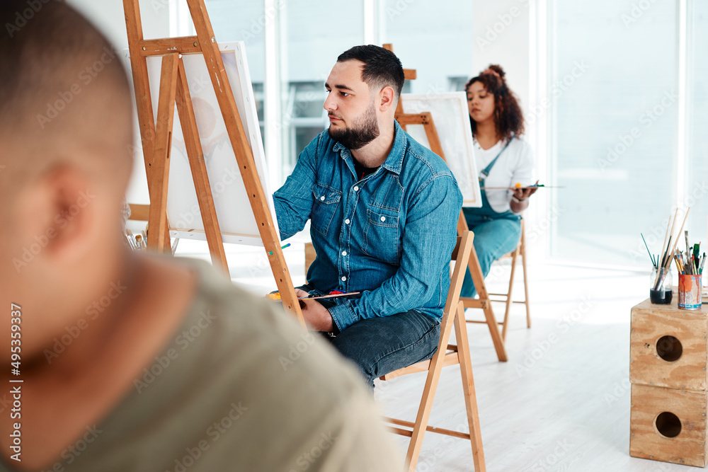 Art is the last form of magic that exists. Cropped shot of a handsome young artist sitting and paint