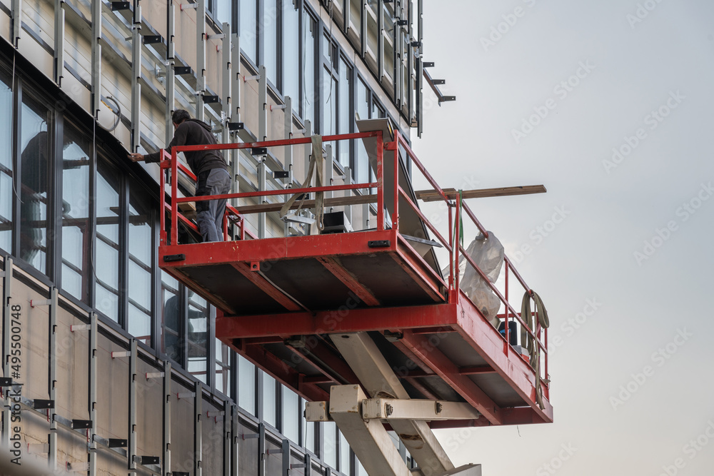 Fensterreinigung an der Fassade eines Industriegebäudes mit Hebebühne