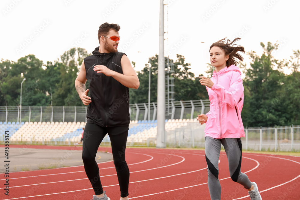 Sporty young couple running at stadium