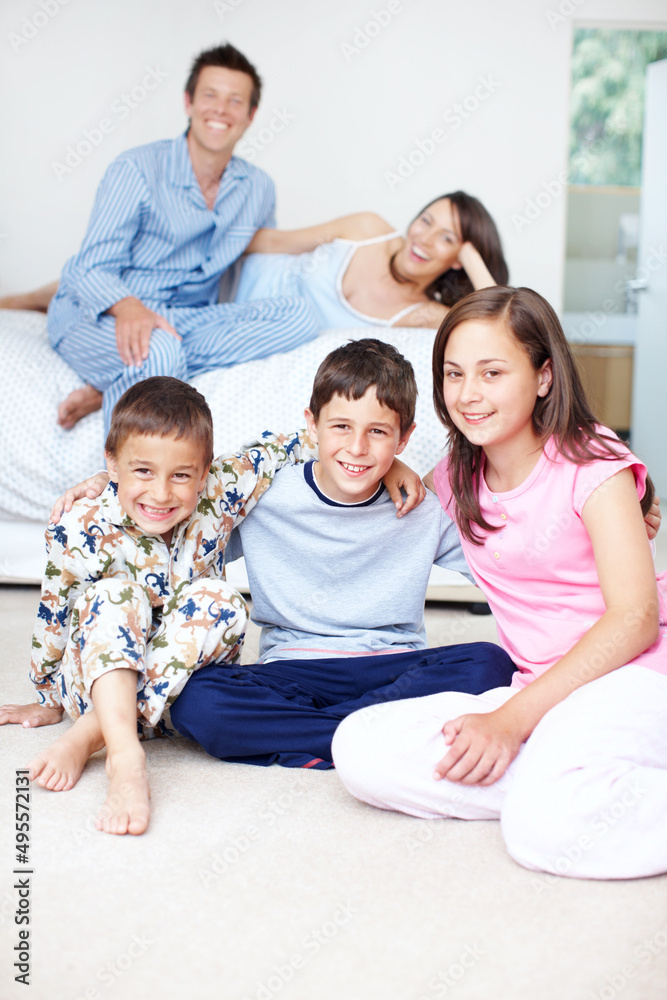 Weve got the whole day to spend together. Portrait of three siblings embracing as their parents sit 