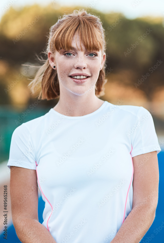 Doing what I love. Shot of an attractive young woman standing alone outside after playing hockey.