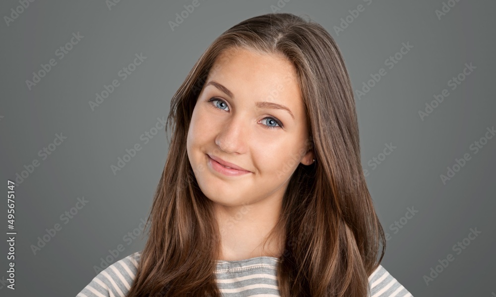 Beautiful face of young woman on grey wall. Successful happy woman.