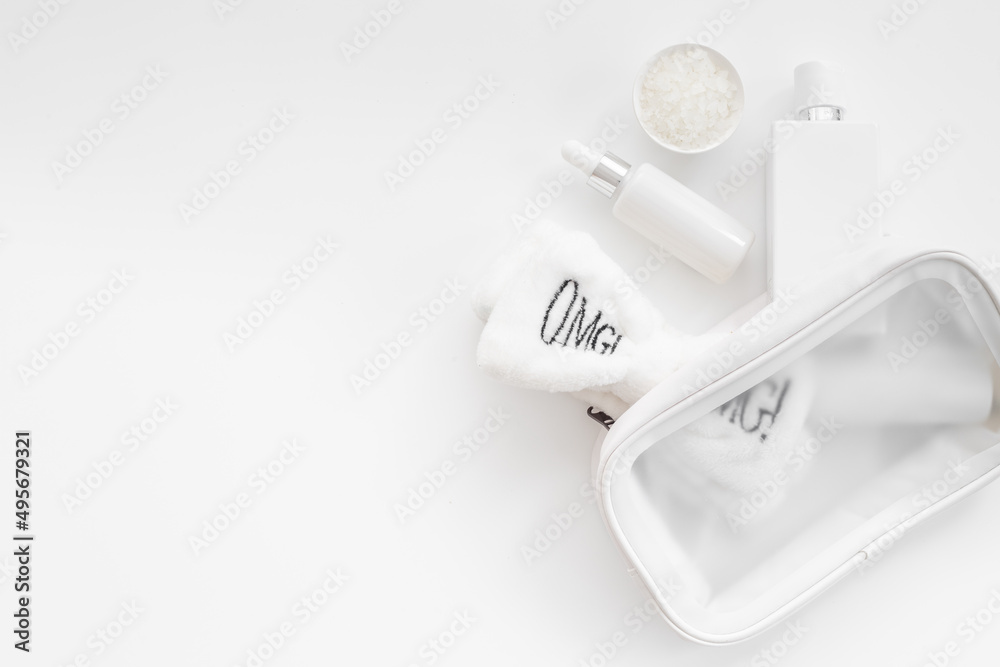 Set of cosmetic bag with white makeup bottles and tubes, top view