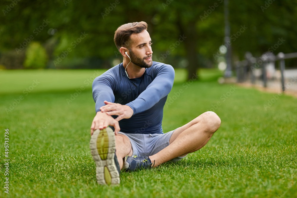 他从不错过热身。一个英俊的年轻男跑步者在赛前热身的全镜头