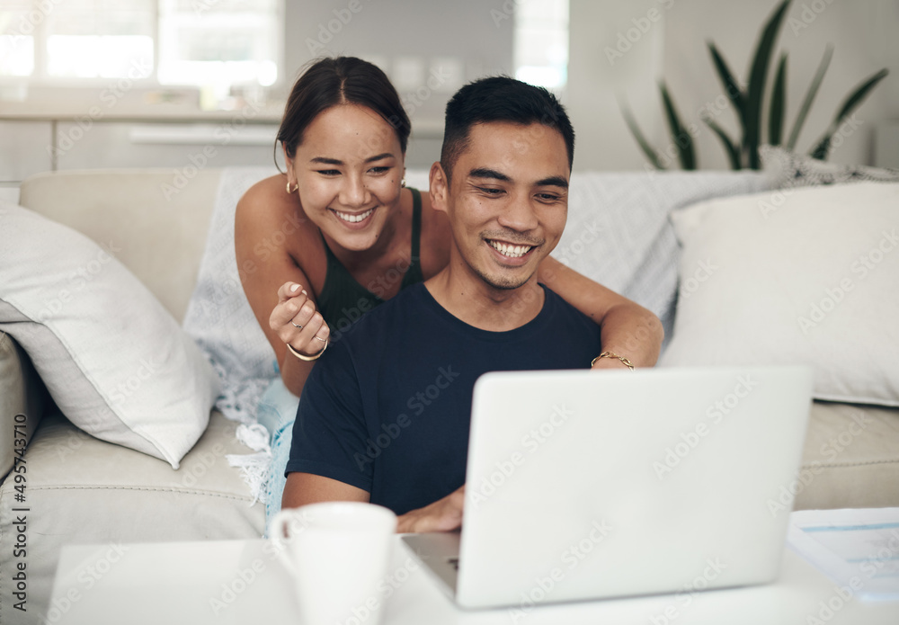 They found something interesting online. Shot of a young couple using a laptop together at home.