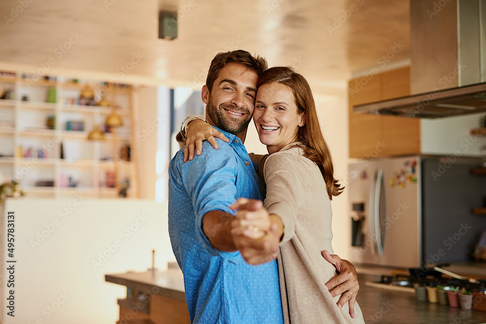 Let love lead. Cropped portrait of an affectionate young couple dancing in their kitchen.