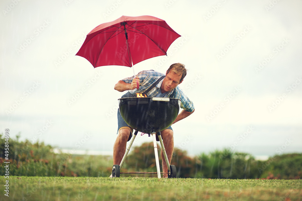 雨停不了我的烧烤。一名男子试图在雨中烧烤的镜头。