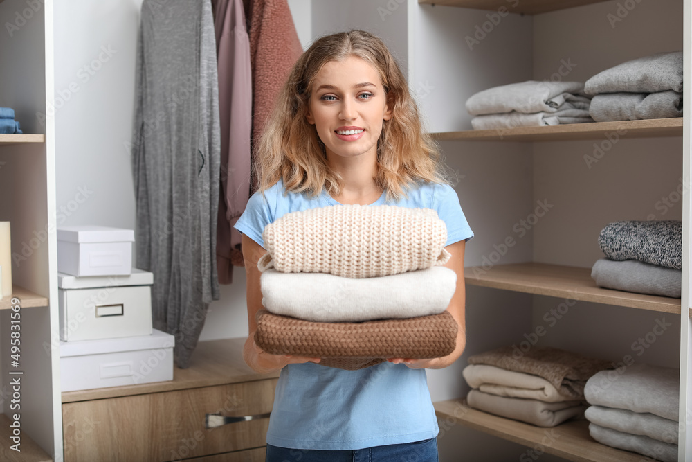 Woman with stack of clean clothes at home