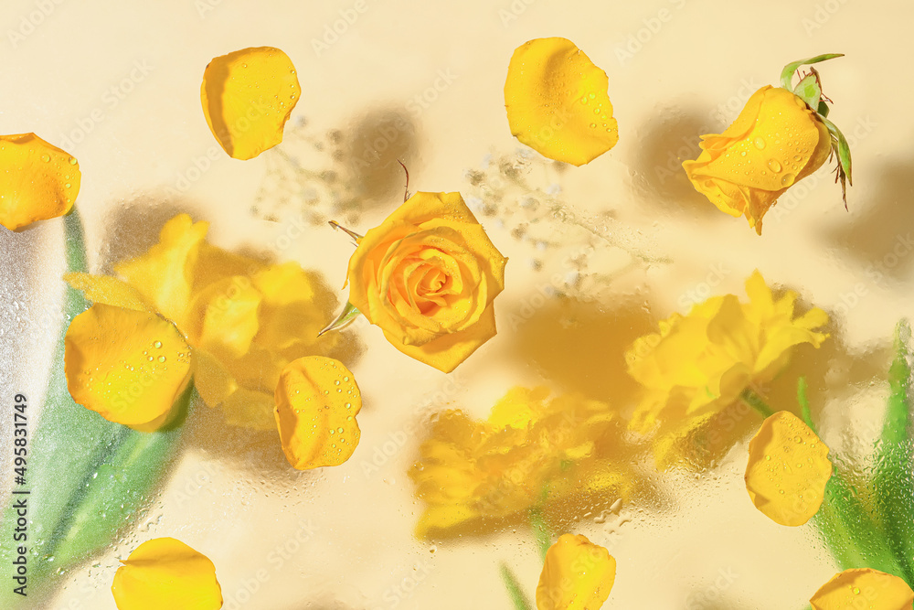 Yellow roses on transparent ice with frozen flowers