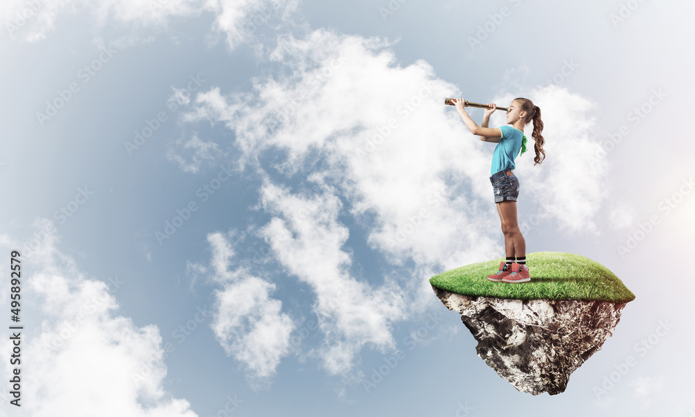 Concept of careless happy childhood with girl looking in spyglass