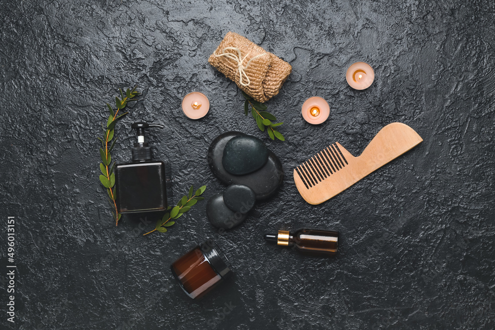 Bathing supplies with cosmetics and spa stones on dark background