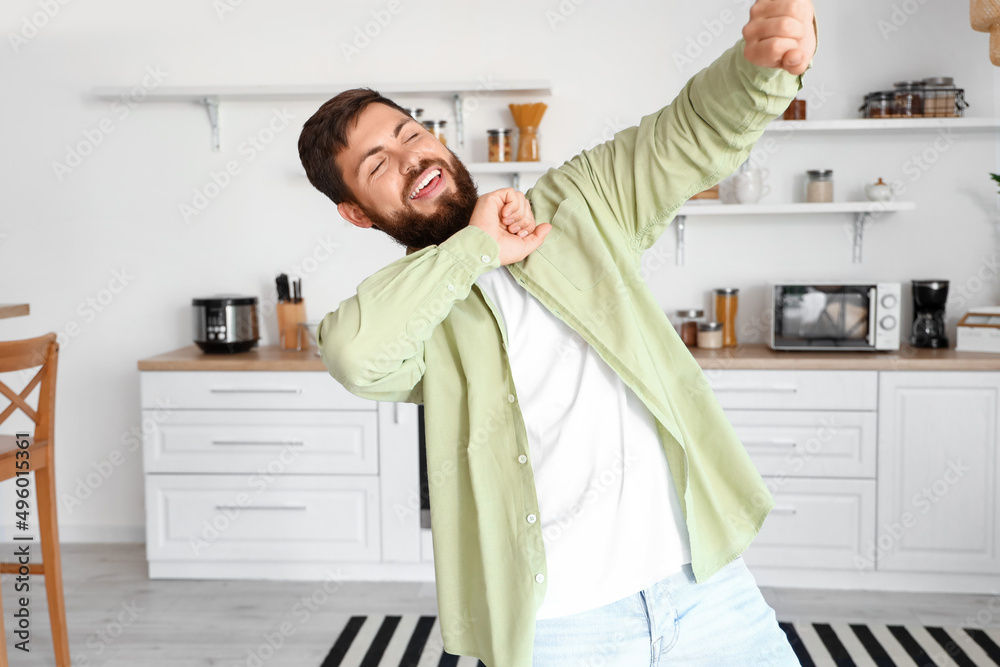 Handsome man dancing in kitchen