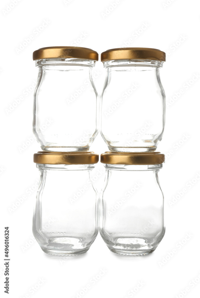 Glass jars with golden caps on white background