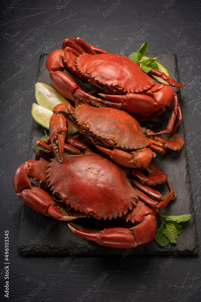 Steamed Red Crab with butter and lemon, Boiled Serrated mud crab on black plate on black background,