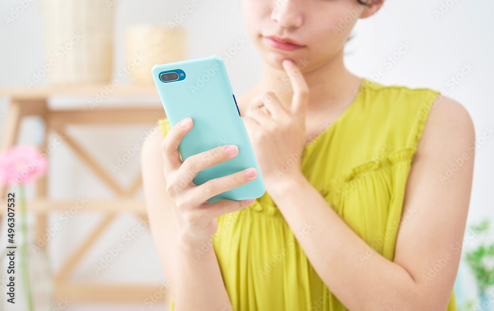 女性　スマホ　考える　顔無し　リビング