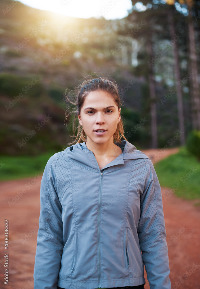 This trail doesnt know it yet, but its owned. Shot of a young woman out for a trail run.