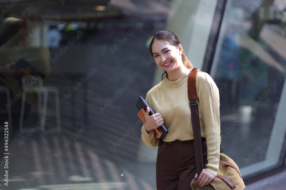 一位年轻的商务女性在机场或市中心行走时携带行李的肖像