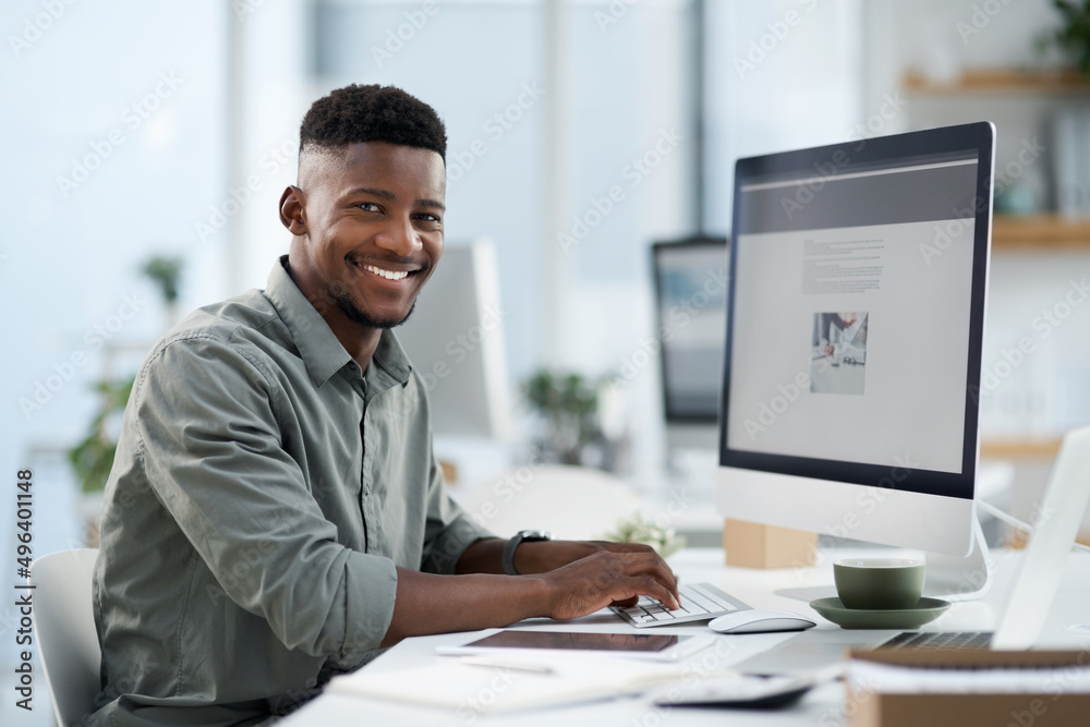 Feeling positive today. Shot of a young businessman working on a computer in an office.