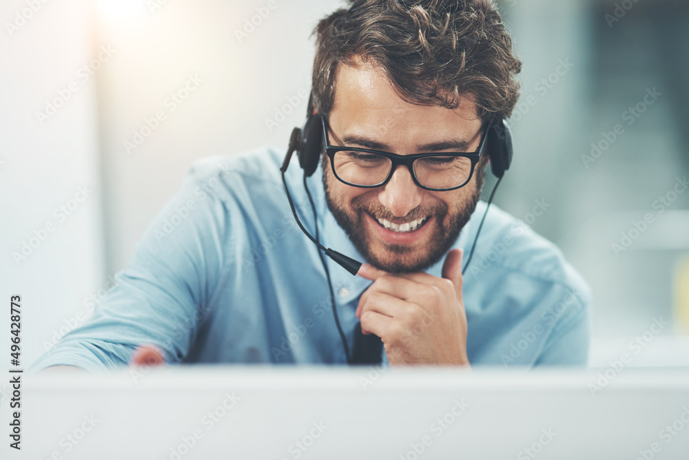 And the lines are open. Shot of a happy young man working in a call center.