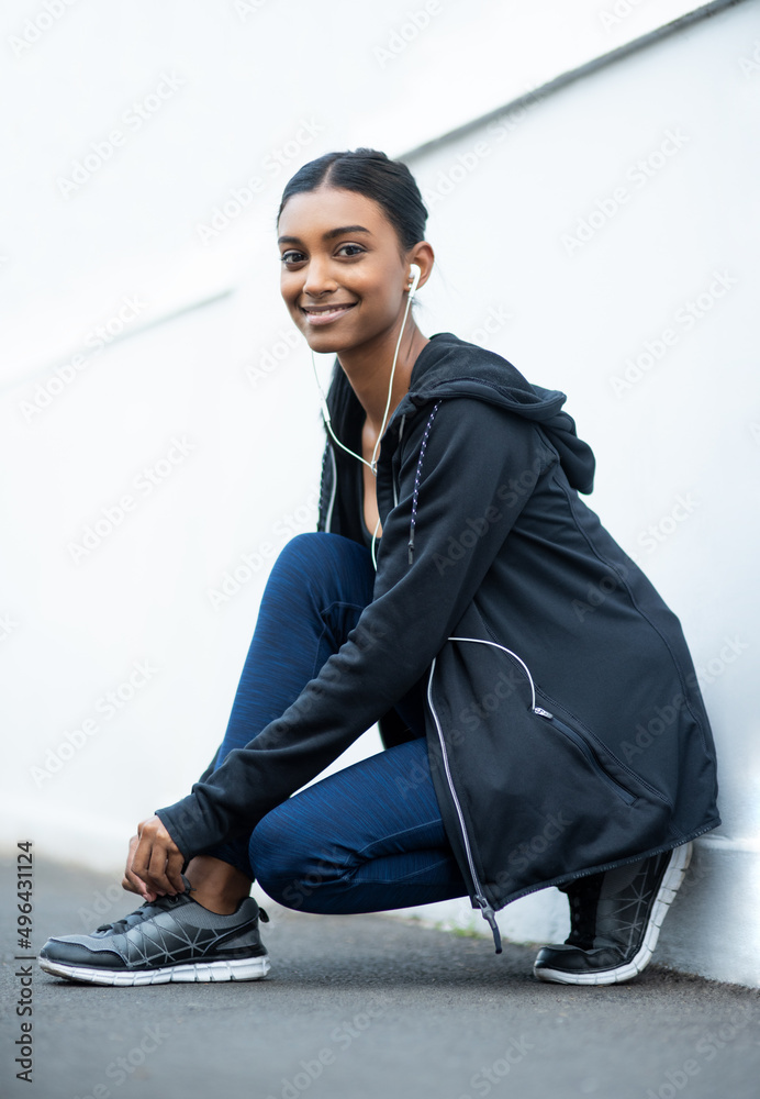 一定要确保我不会绊倒。一位运动型年轻女子在锻炼时系鞋带的肖像