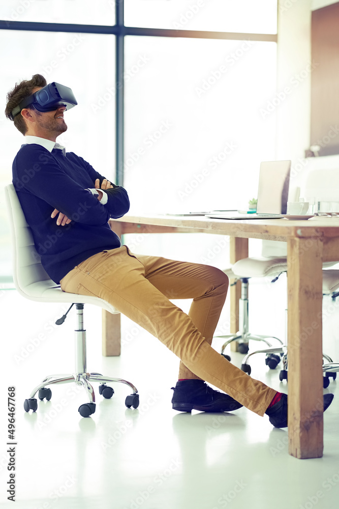 The future never looked better. Shot of a businessman wearing a VR headset while leaning back in his