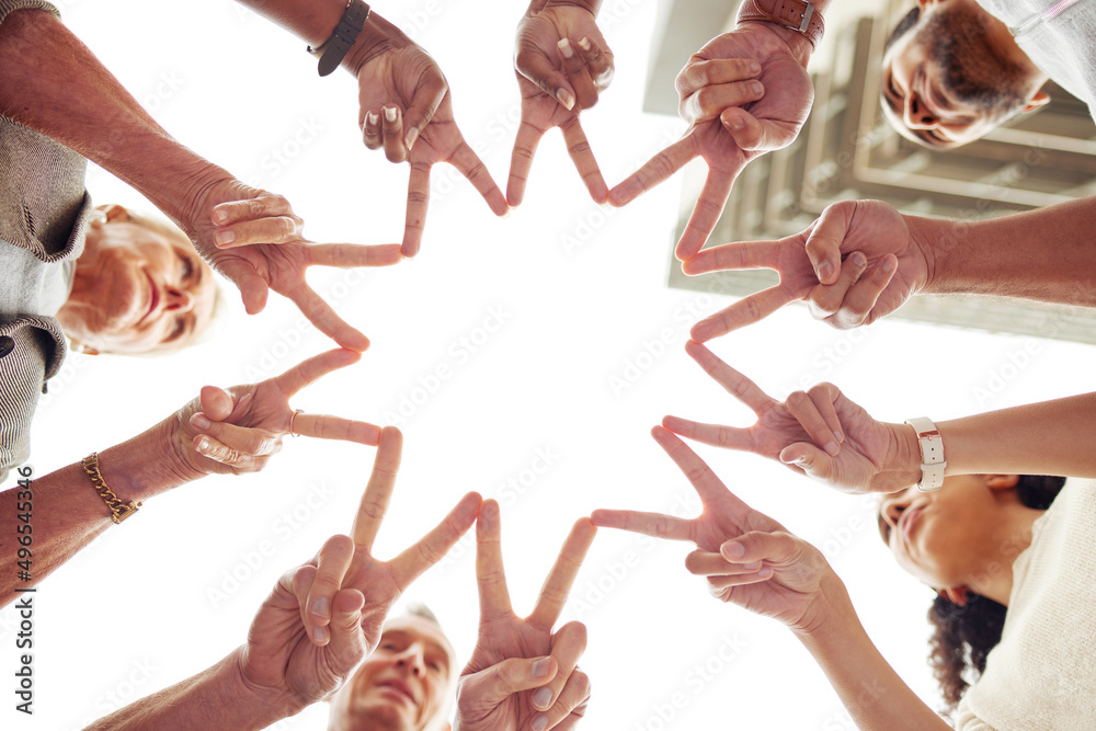 Were shooting for the stars. Low angle shot of a group of unrecognisable people making a peace sign 