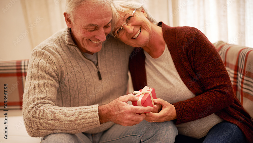 Thankful for love on Christmas. Shot of a senior couple exchanging gifts at christmas.