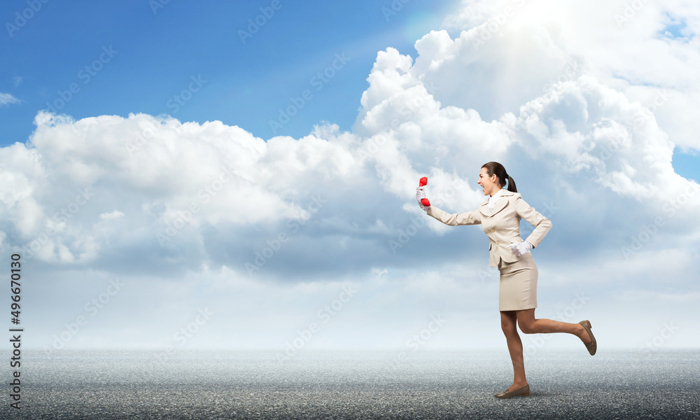 Woman running outdoor with vintage red phone