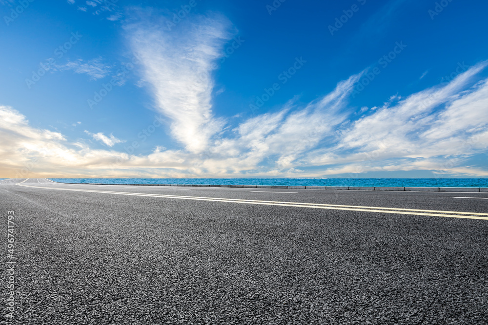 蓝天下湖边空旷的柏油路。道路和天空背景。