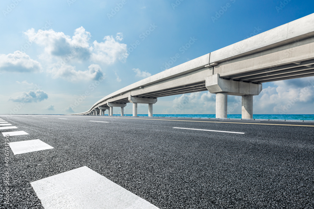 蓝天下有桥的空沥青路和河