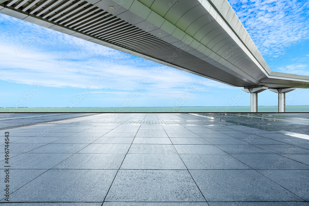 Empty square floor and bridge with river under blue sky