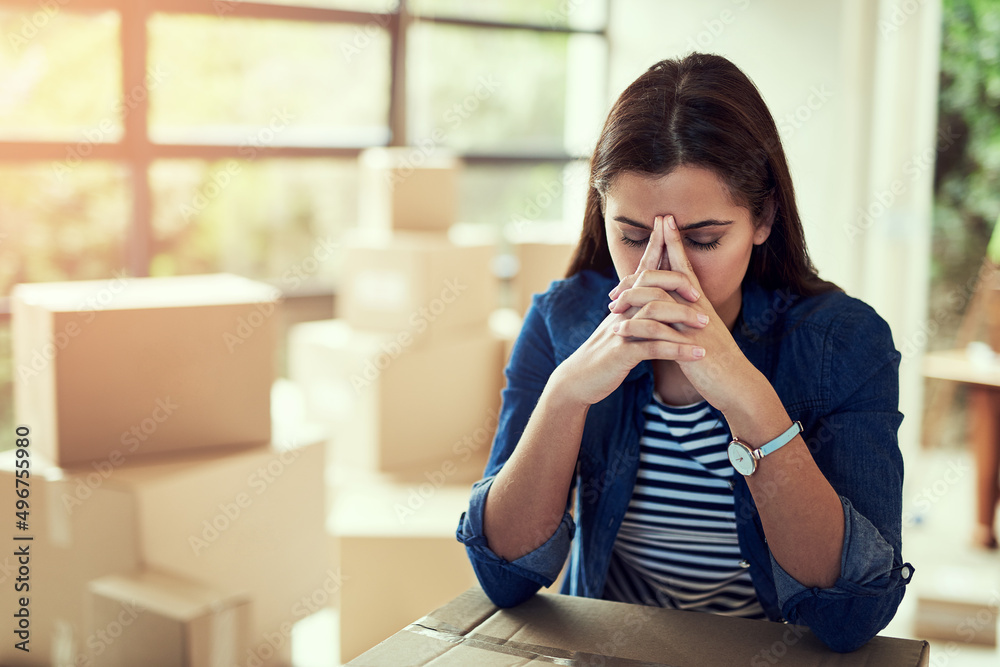 Moving can be quite exhausting and stressful. Cropped shot of a young woman looking stressed out whi