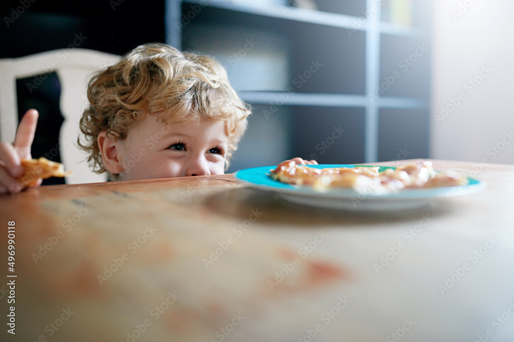 Its so yummy. Shot of an adorable little boy eating at home.