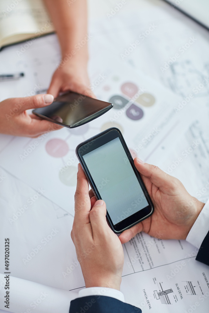 Ill send you a few helpful business cards. Cropped shot of two businesspeople using their cellphones