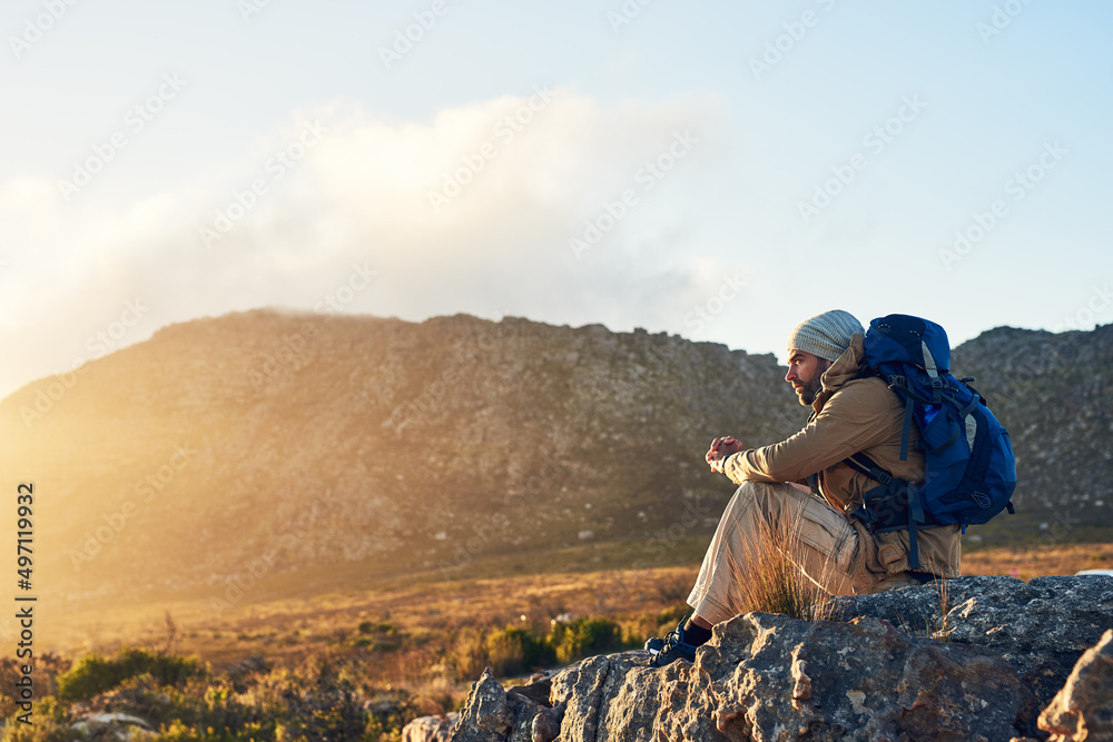 不要经历生活，要在生活中成长。一个徒步旅行者坐在山顶思考的镜头。