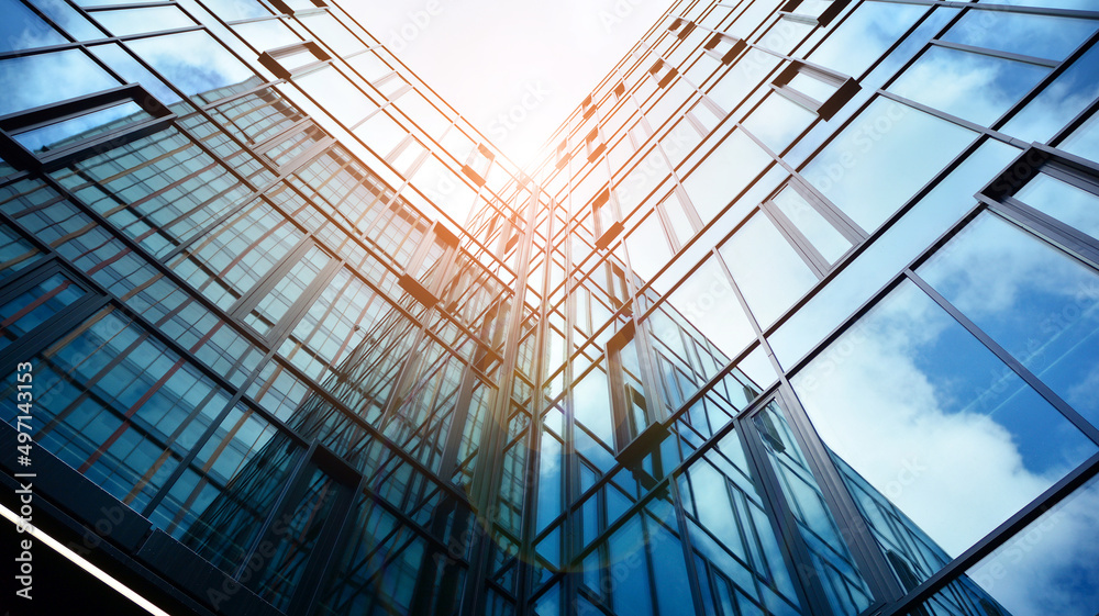 Modern office building with glass facade on a clear sky background. Abstract close up of the glass-c