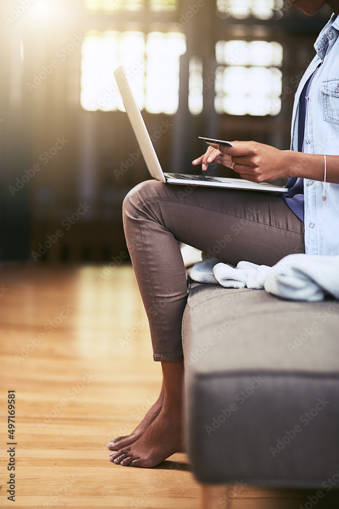 Nothing beats the convenience of credit. Cropped shot of a woman using a laptop and credit card on t