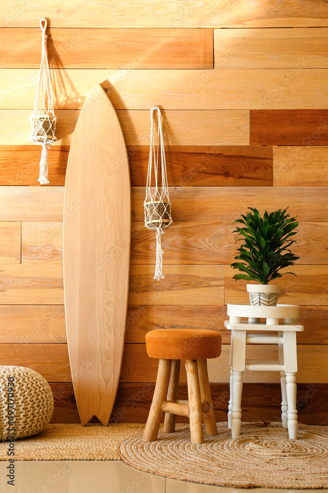 Interior of stylish room with wooden surfboard and houseplants