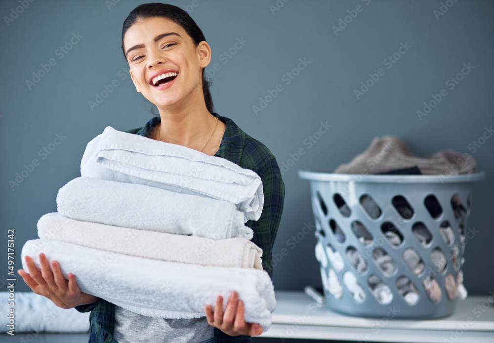 All washed and folded. Cropped portrait of an attractive young woman carrying a pile of towels while