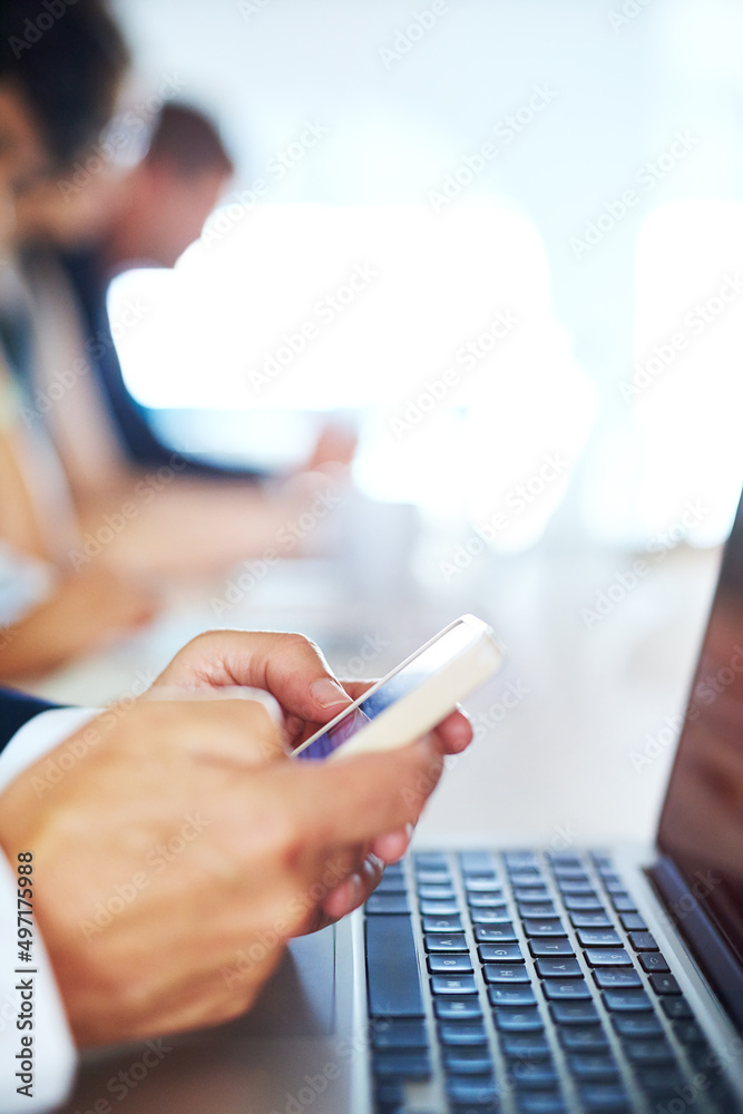 Connecting with opportunities for success. Cropped shot of a businessman using his phone and laptop 