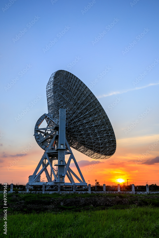 Astronomical radio telescope and beautiful sky clouds at sunset