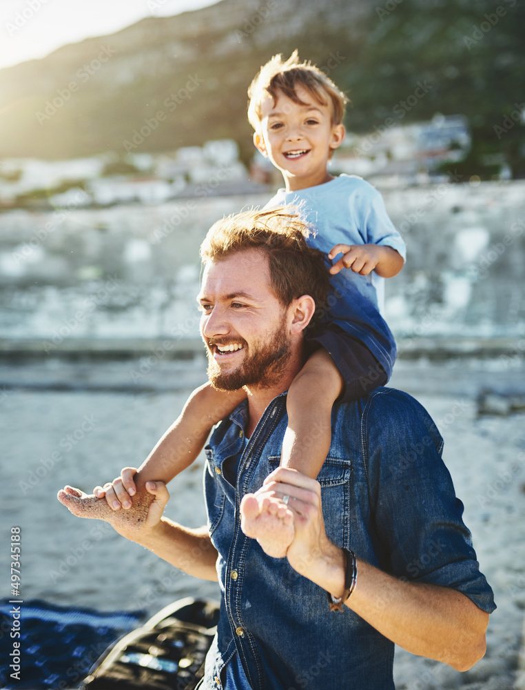 Sitting on Daddys shoulders makes me feel taller. Shot of a young Father and son spending quality ti