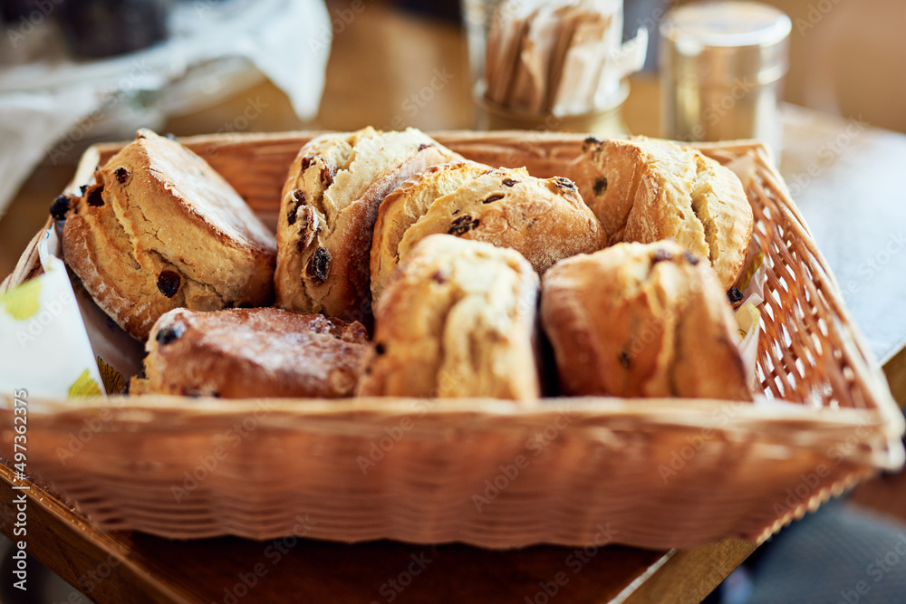 They go so well with our coffees. Cropped shot of freshly baked scones in a basket.